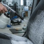 Tornador voiture : pistolet pneumatique pulvérisant une mousse sur le siège en tissu