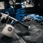 Pistolet nettoyage voiture branché sur compresseur pour nettoyer les surfaces